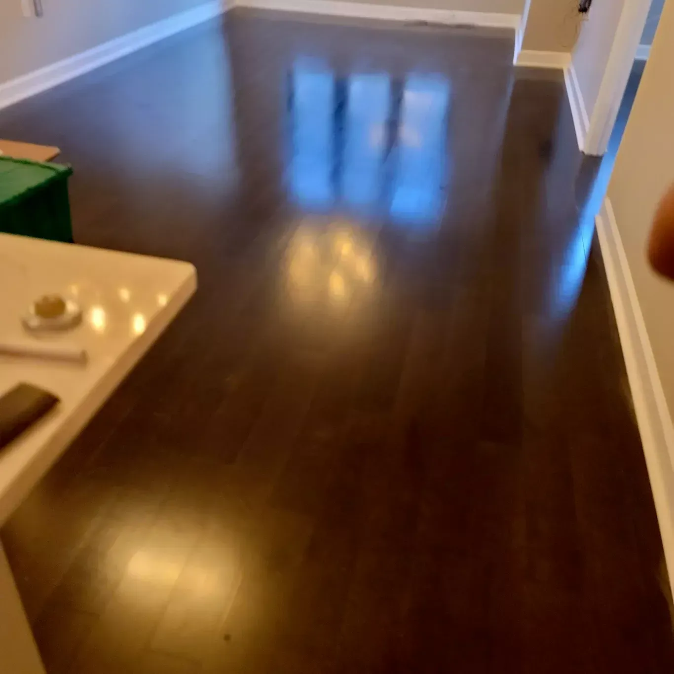 A person is standing in a living room with a wooden floor.