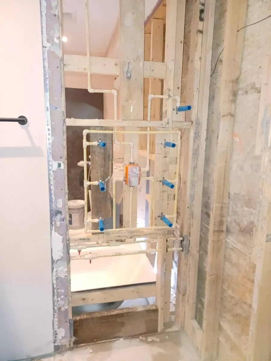 A bathroom under construction with a door that is open