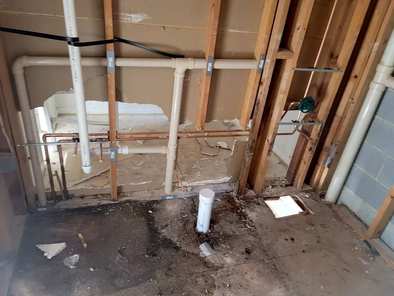 A bathroom with a lot of pipes coming out of the wall.