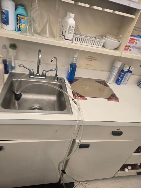 Clinic sink and countertop with soap dispensers, paper towels, and shelves of supplies