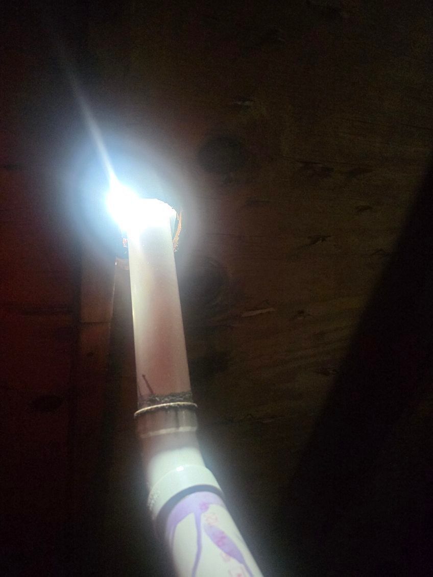 Lit white candle in a decorative holder in a dark room