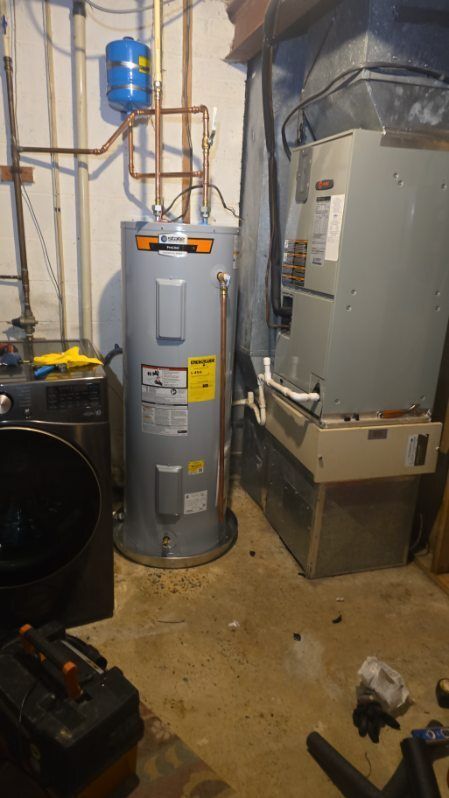 Utility room with a water heater and HVAC furnace beside a pipe and blue expansion tank
