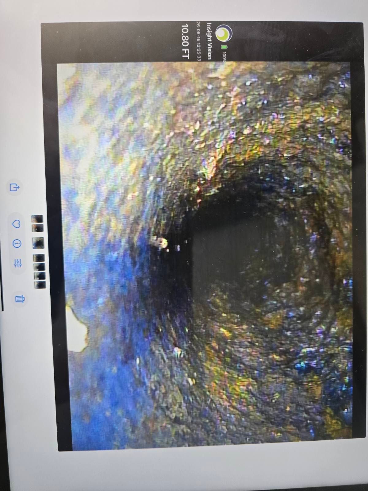 Photo of a screen showing a dark, circular tunnel with blue and yellow reflections