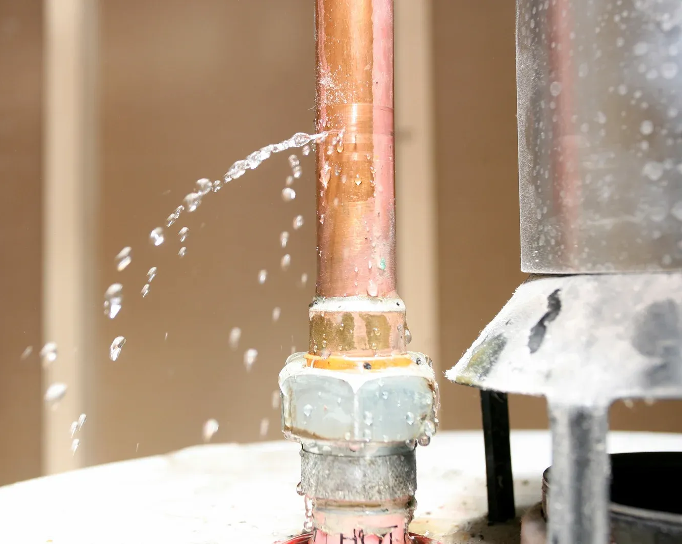 A sink with a drain pipe and a copper pipe underneath it.