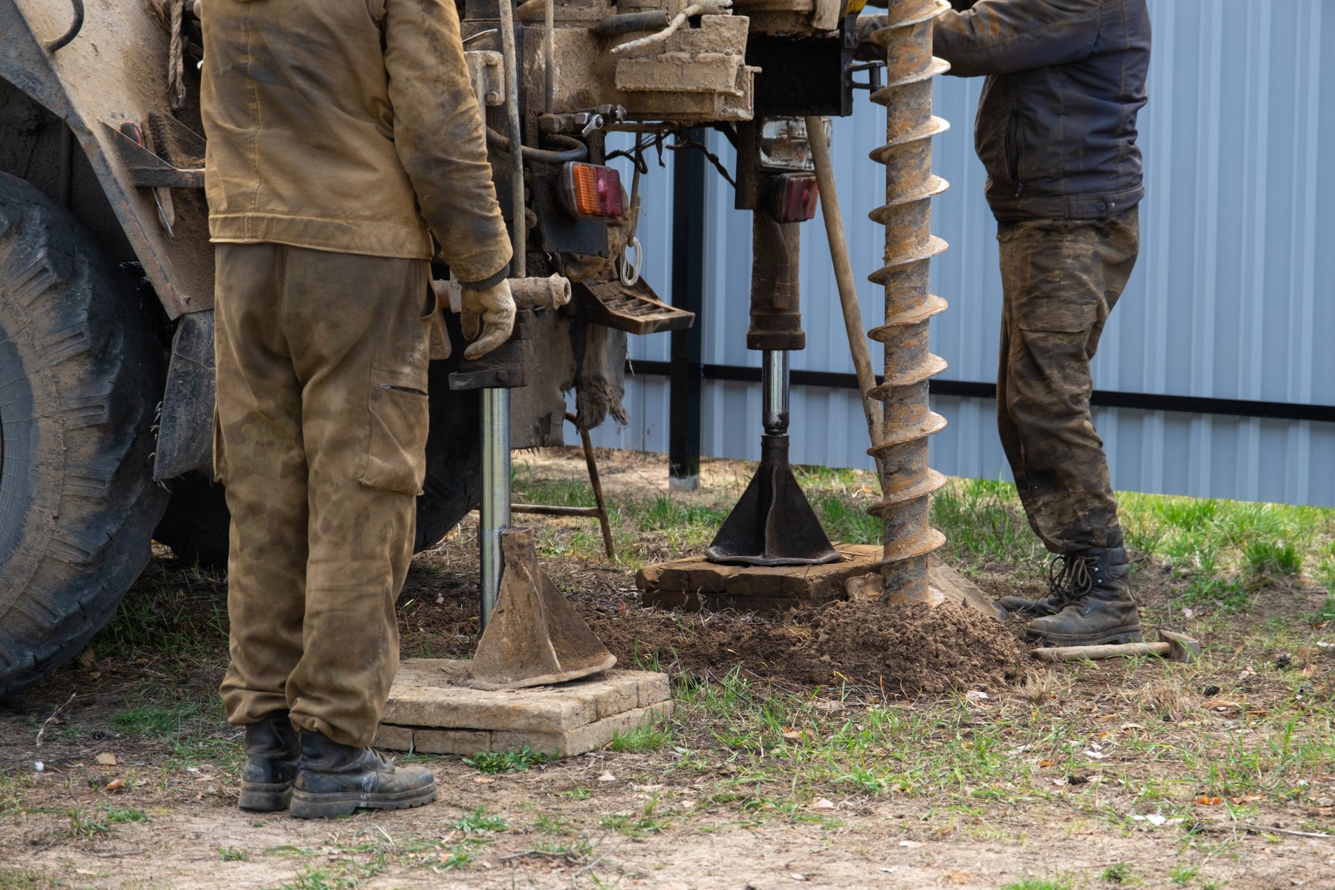Workers drilling water well with auger drill rig machine on residential property. Workers drilling water well with auger drill rig machine on residential property.