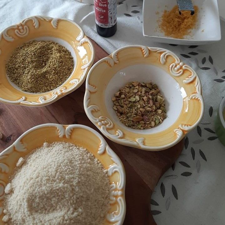 Schalen gevuld met de volgende ingrediënten: gemalen noten, pistachenoten, amandelmeel en citroenschil.