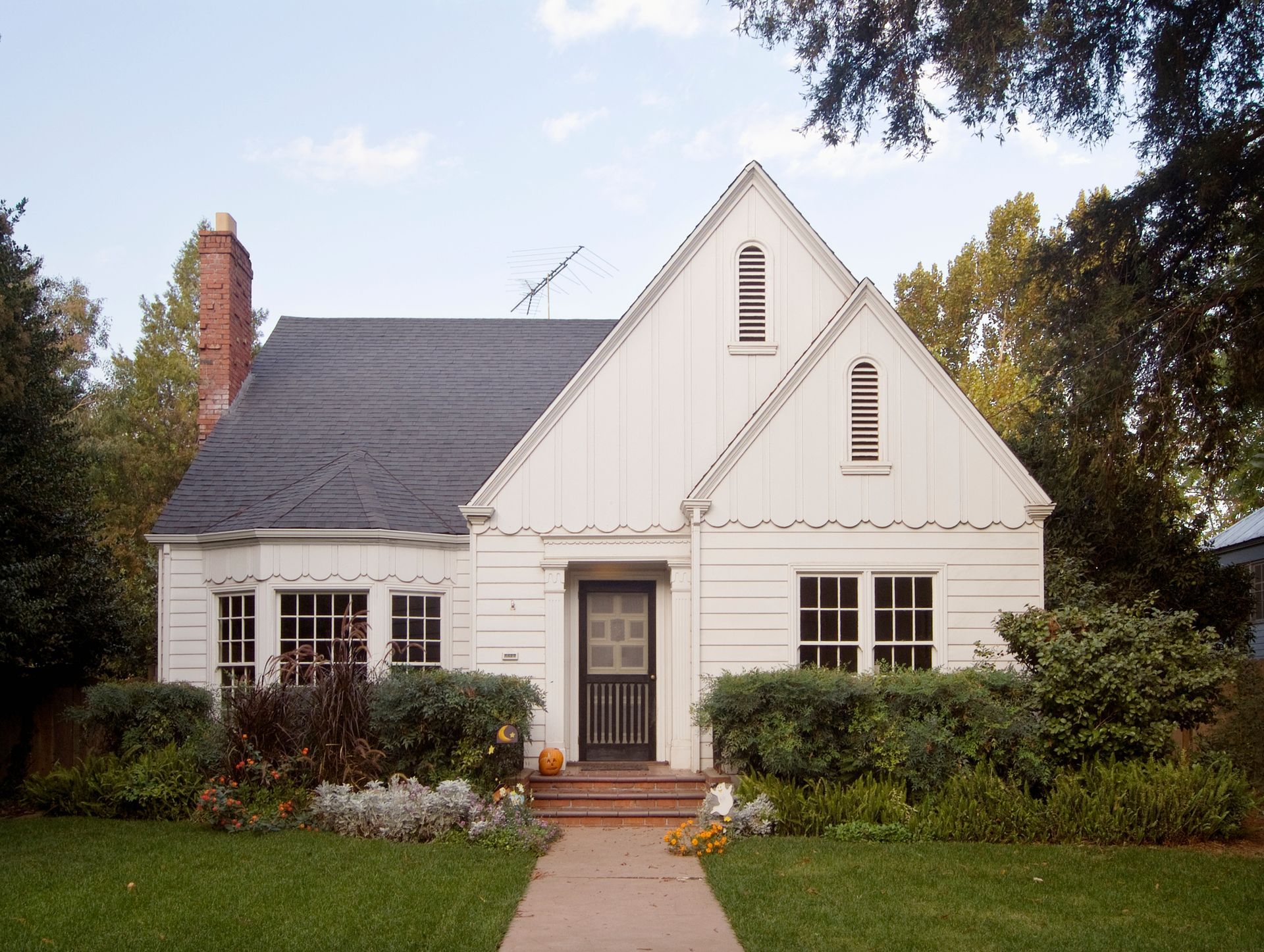 A white house with a black roof and a black door