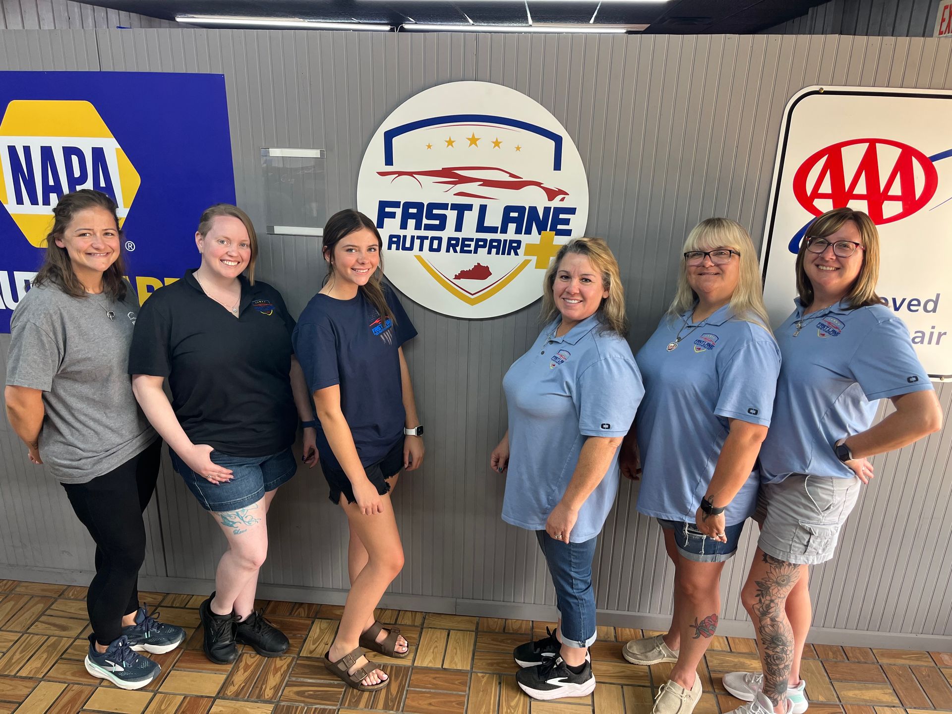 Six employees posing in front of NAPA and AAA Fast Lane Auto Repair signs