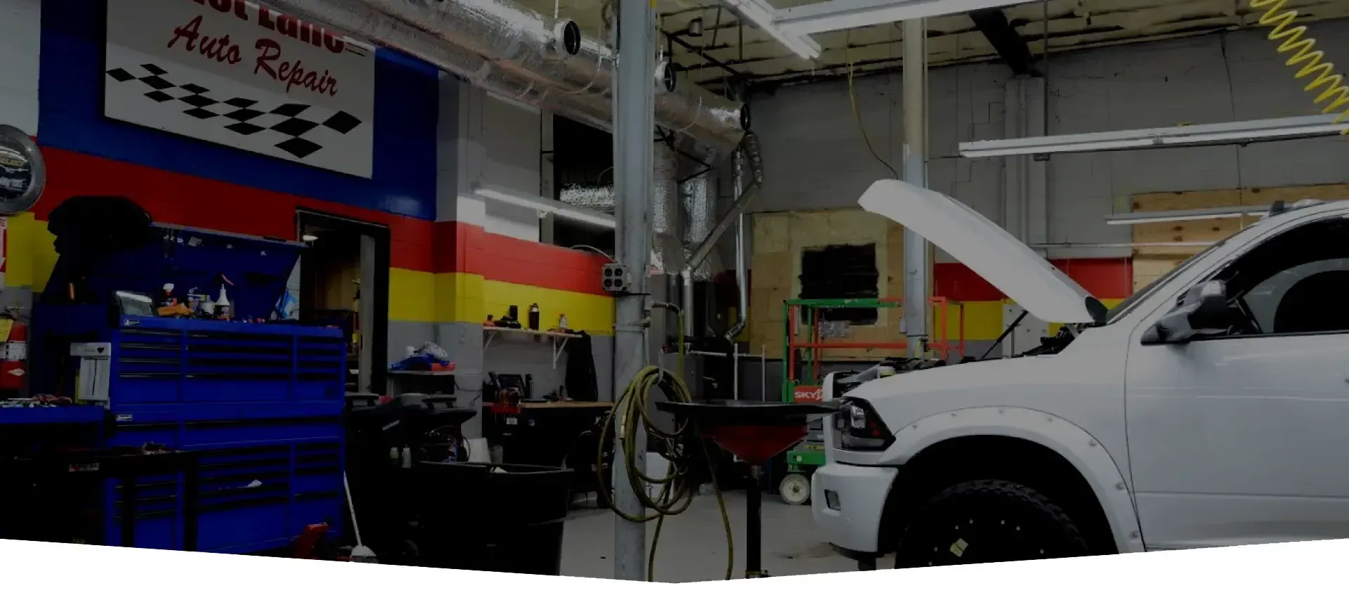 White truck in garage with hood up | Fast Lane Auto Repair