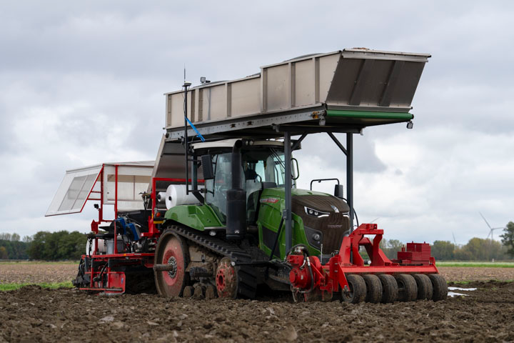 De bollenplanter aan het werk op het land