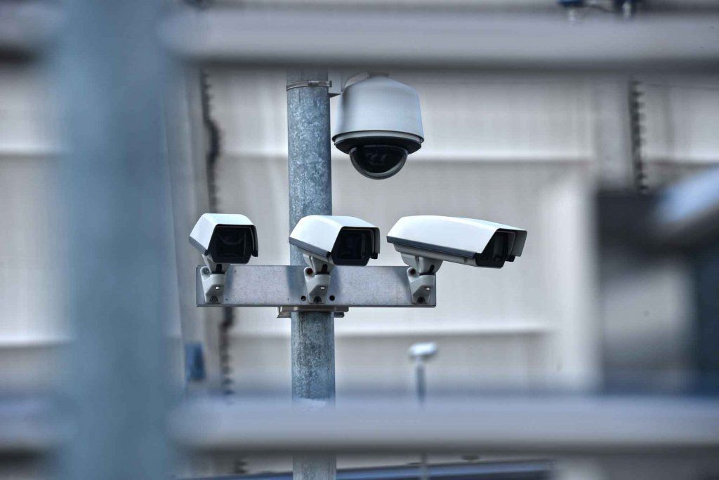 Three Security Cameras Are Mounted On A Pole Outside Of A Building — Country to Coast Cabling in Kawana, QLD