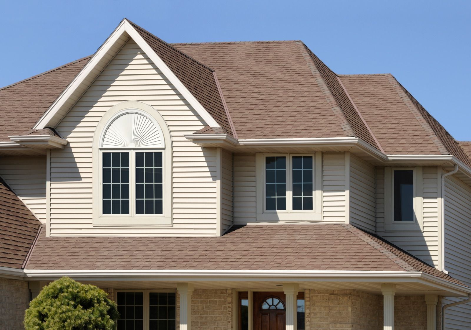 A house with a brown roof and white siding
