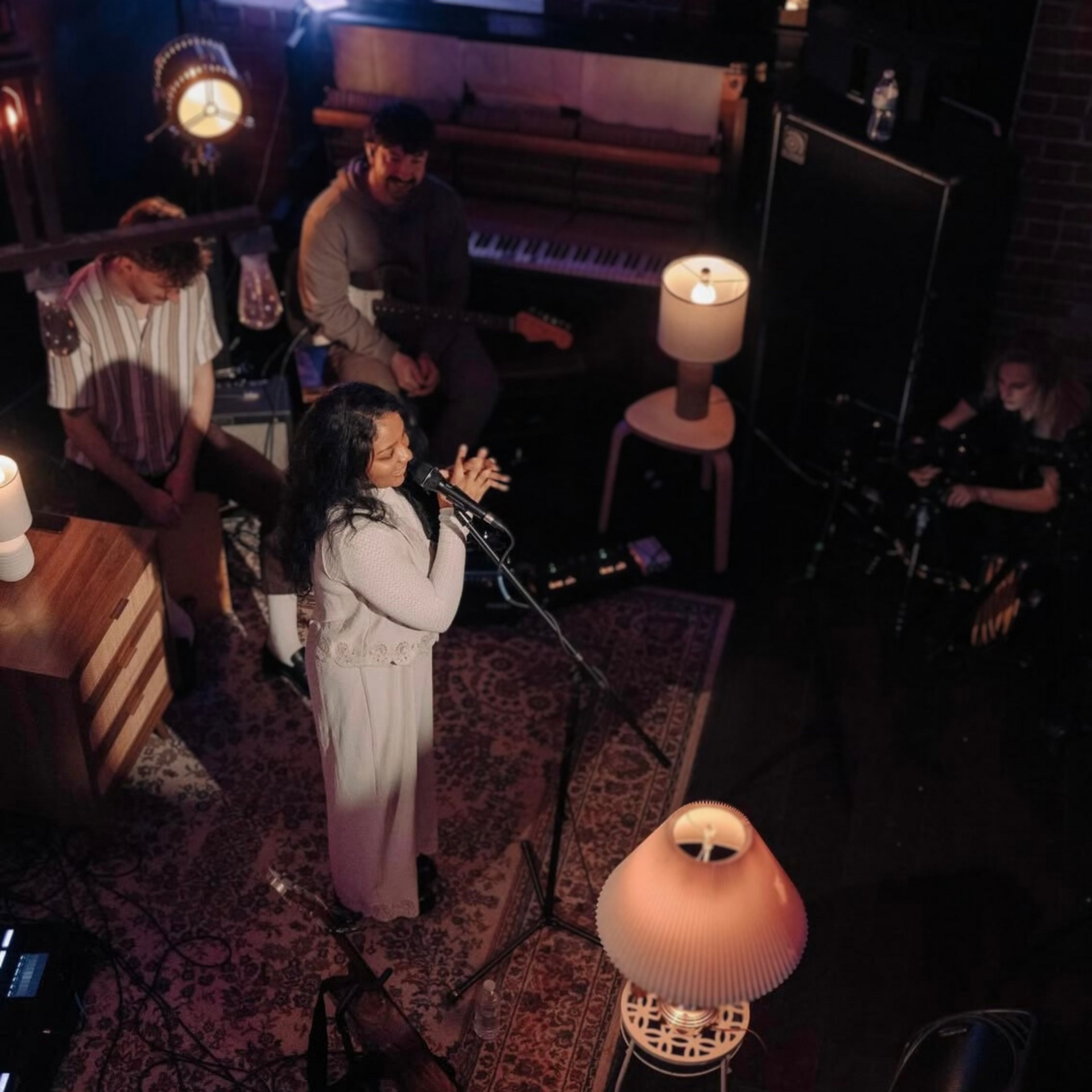 A woman singing into a microphone in a dark room
