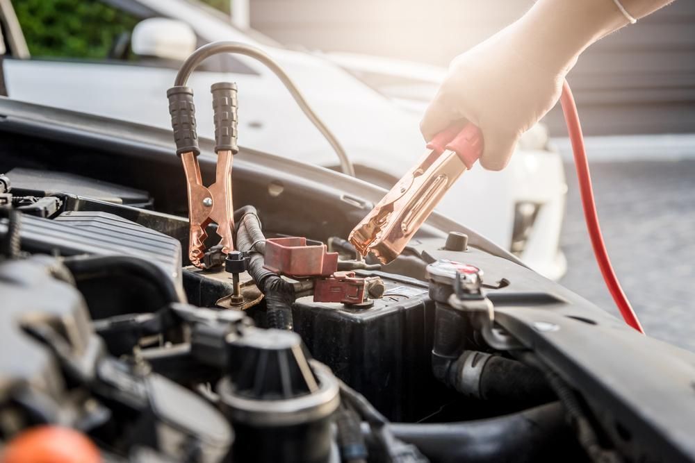 A Person Is Charging A Car Battery With Jumper Cables — SG Mobile Mechanic In Newcastle, NSW