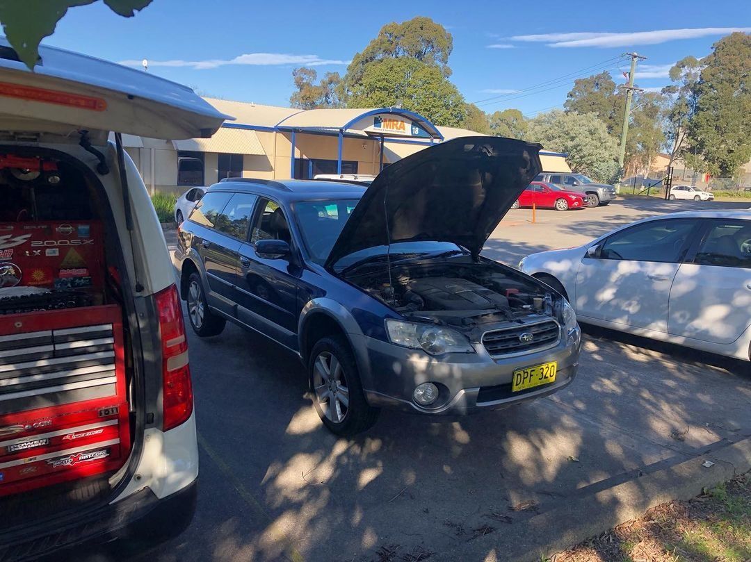A Car With Its Hood Up Is Parked In A Parking Lot Next To A Van — SG Mobile Mechanic In Newcastle, NSW