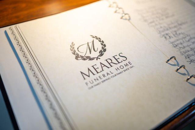 Mares Funeral Home booklet on a table, with a decorative cover and pen nearby