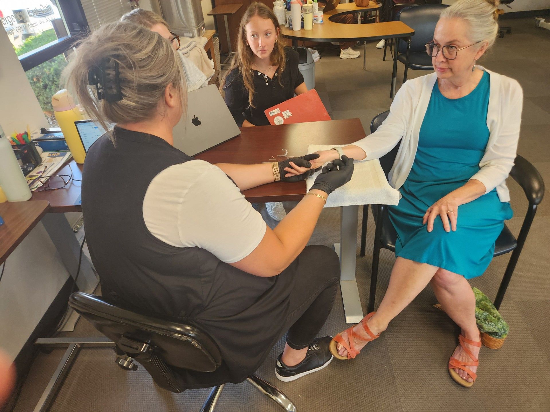 Seated woman gets therapy on hand 