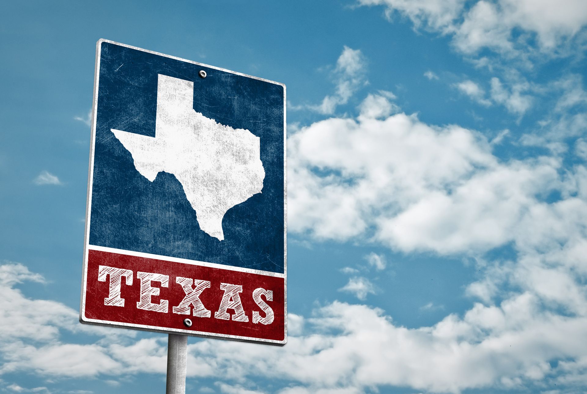 A rectangular sign displays a white map of Texas on a blue background above a red panel reading 