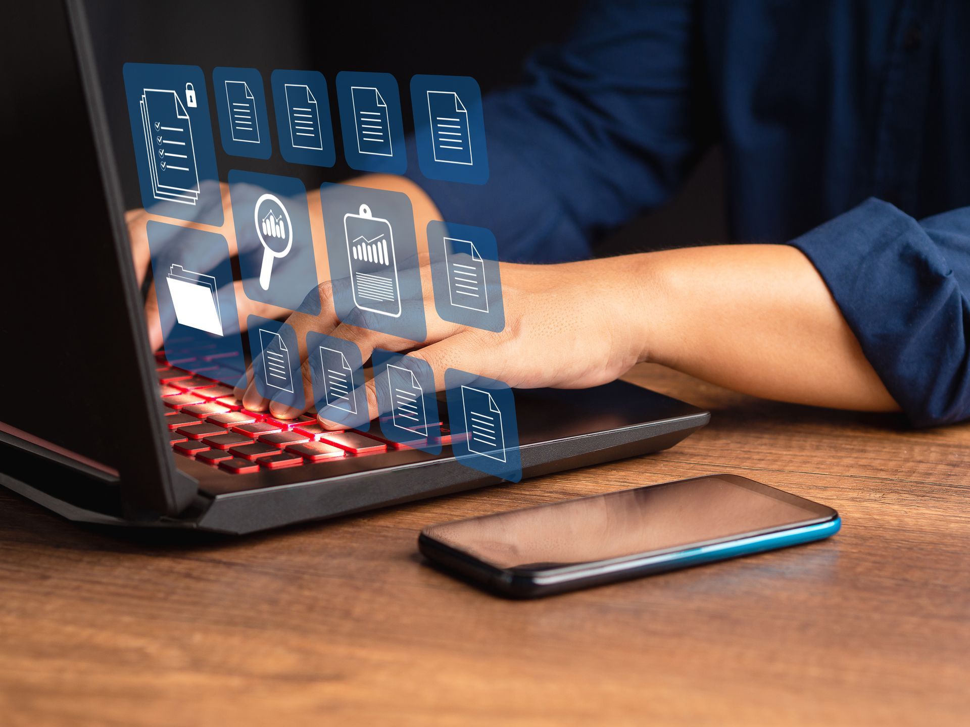 A person typing on a laptop with holographic business and file icons floating above the keyboard.