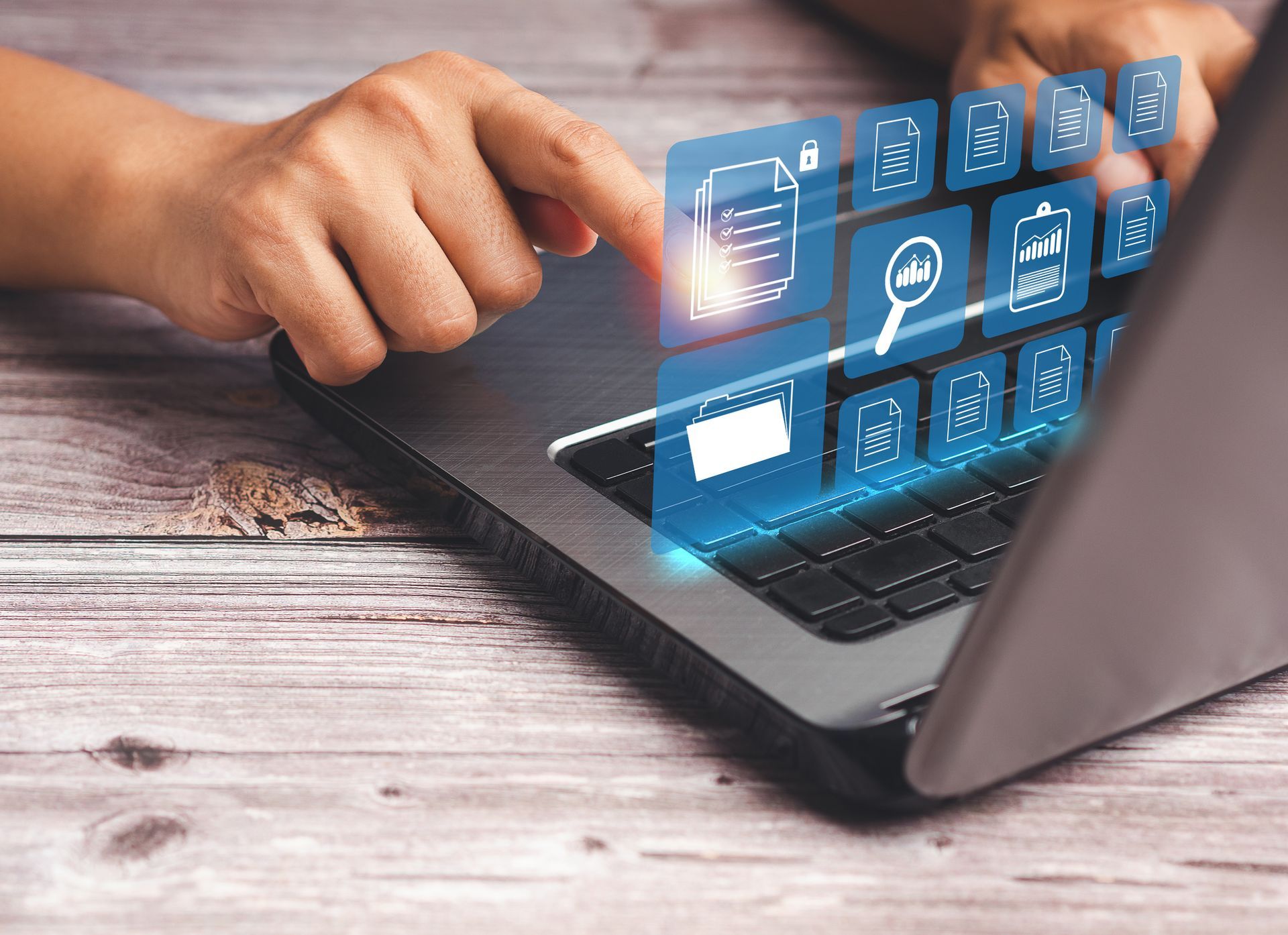 A person touching a laptop keyboard with a digital overlay of glowing business and data analysis icons.