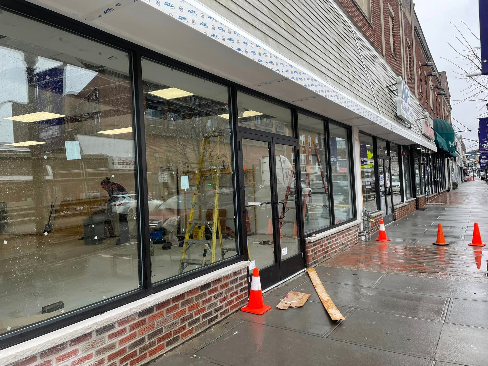 A building with a lot of windows is being remodeled on a rainy day.