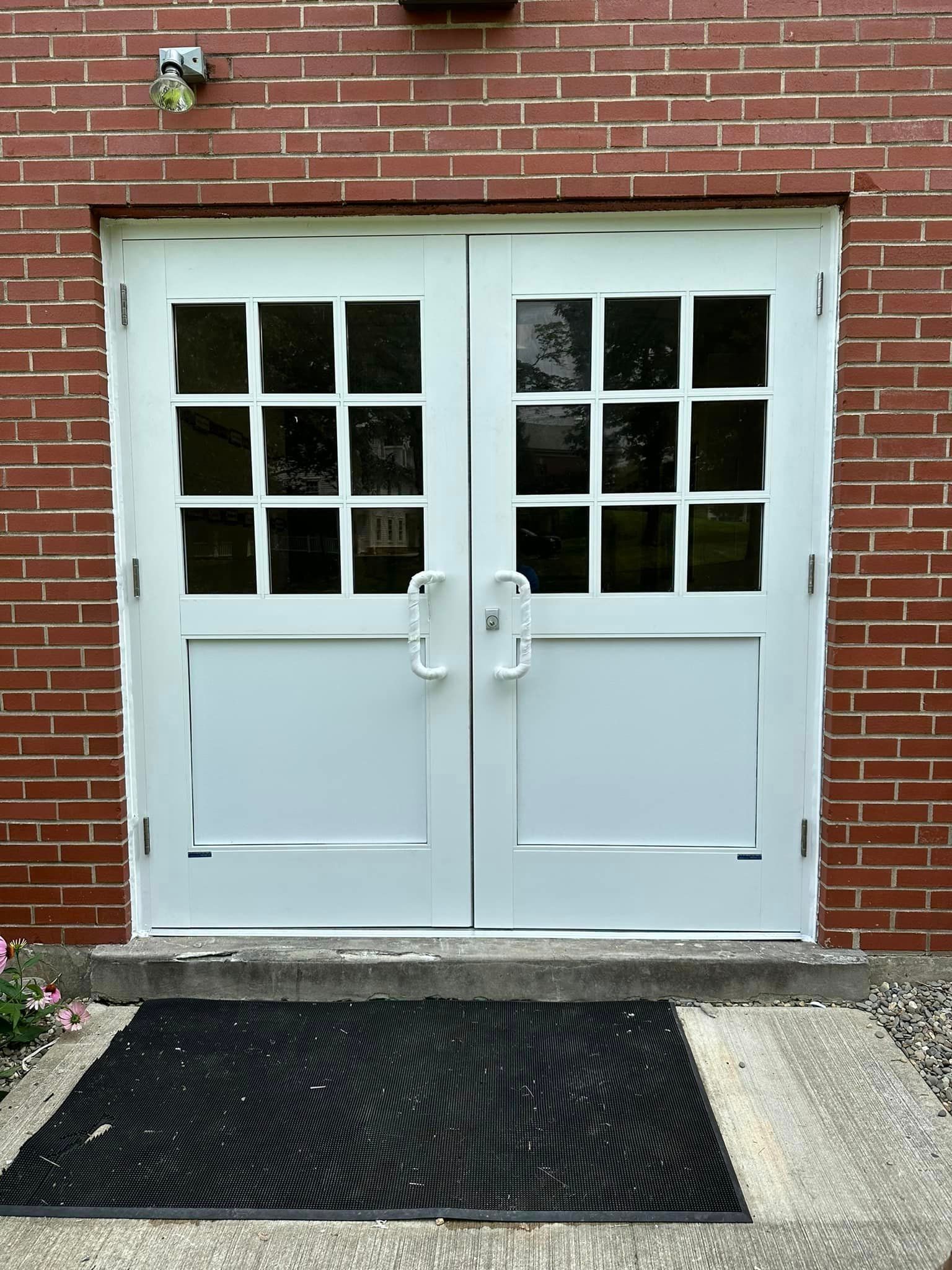 A pair of white doors on a brick building