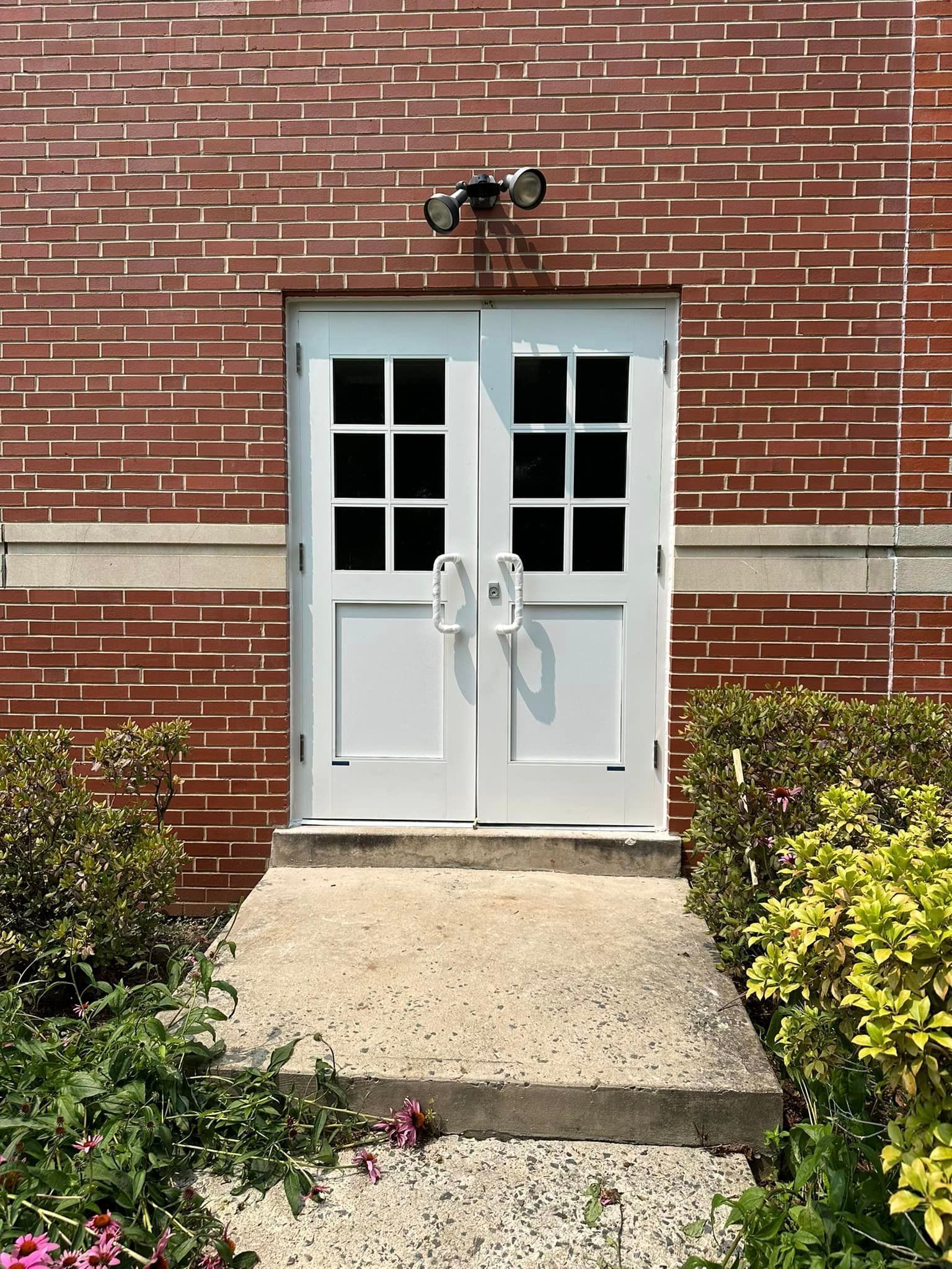 A brick building with a white door and steps leading to it.