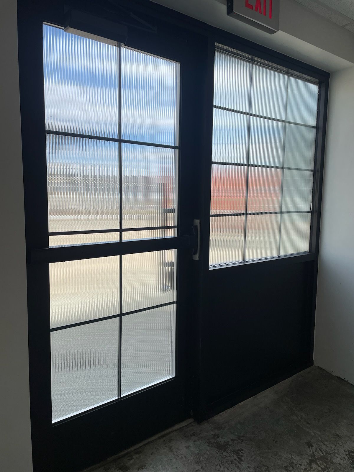 A black door with a red exit sign above it