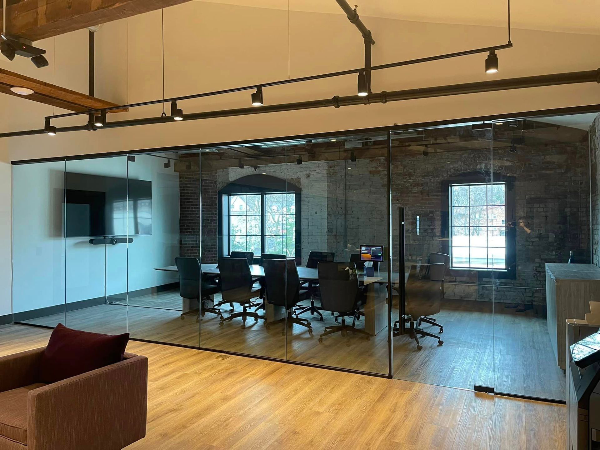 A conference room with a glass wall and a table and chairs.