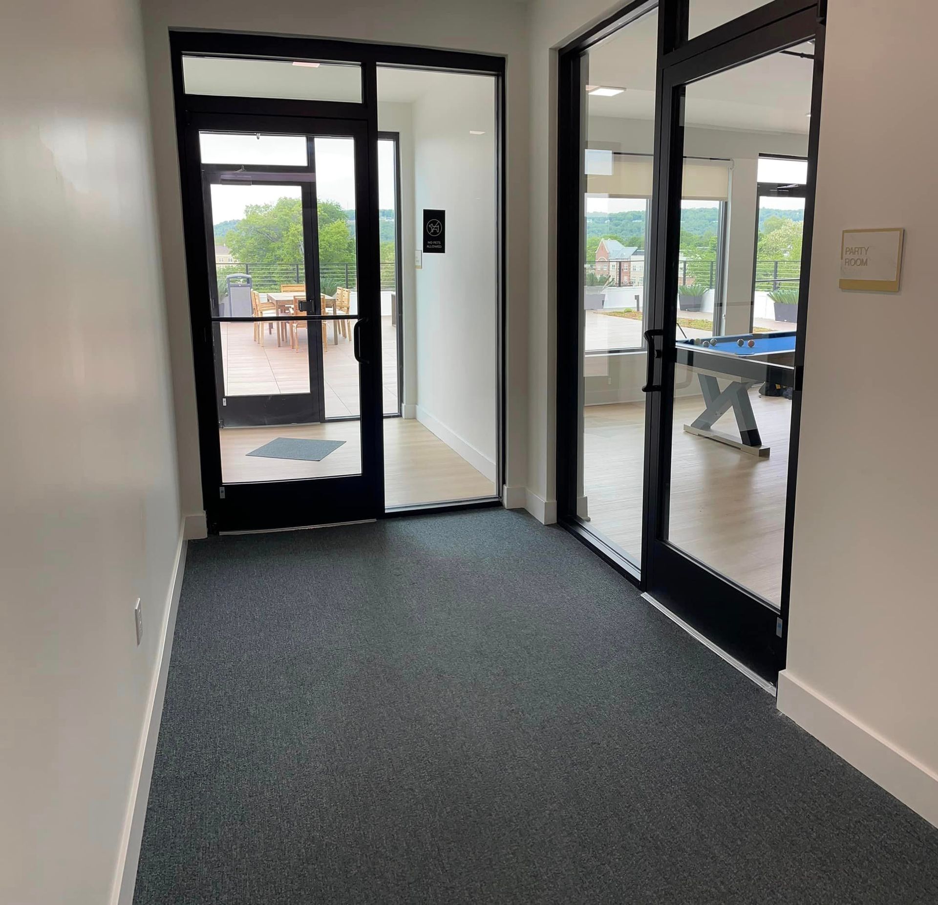 A hallway with a pool table in the background