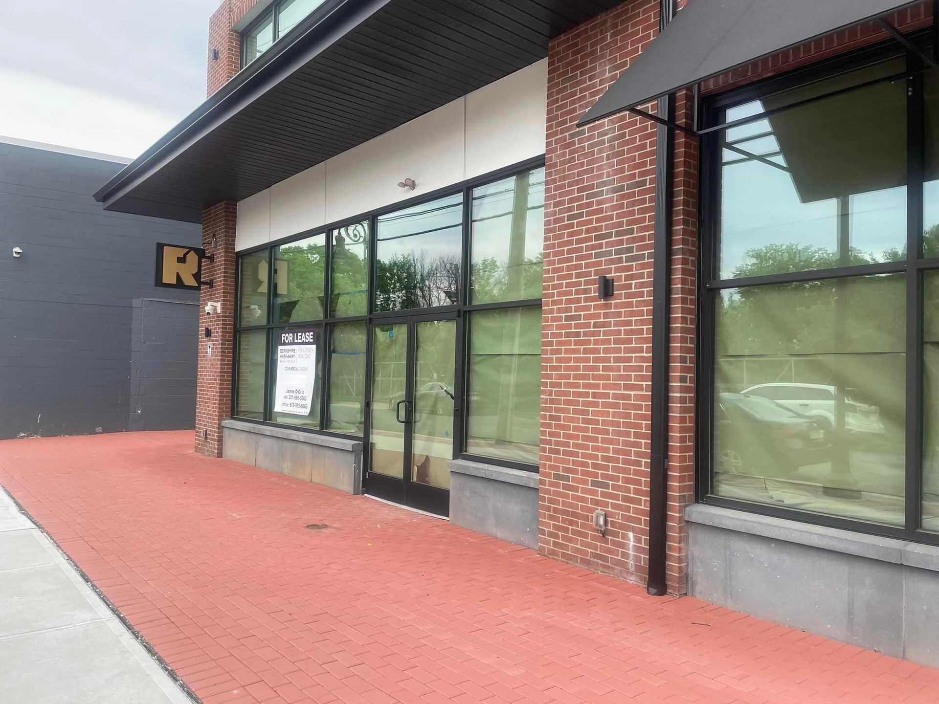 A large brick building with a lot of windows and a red sidewalk.