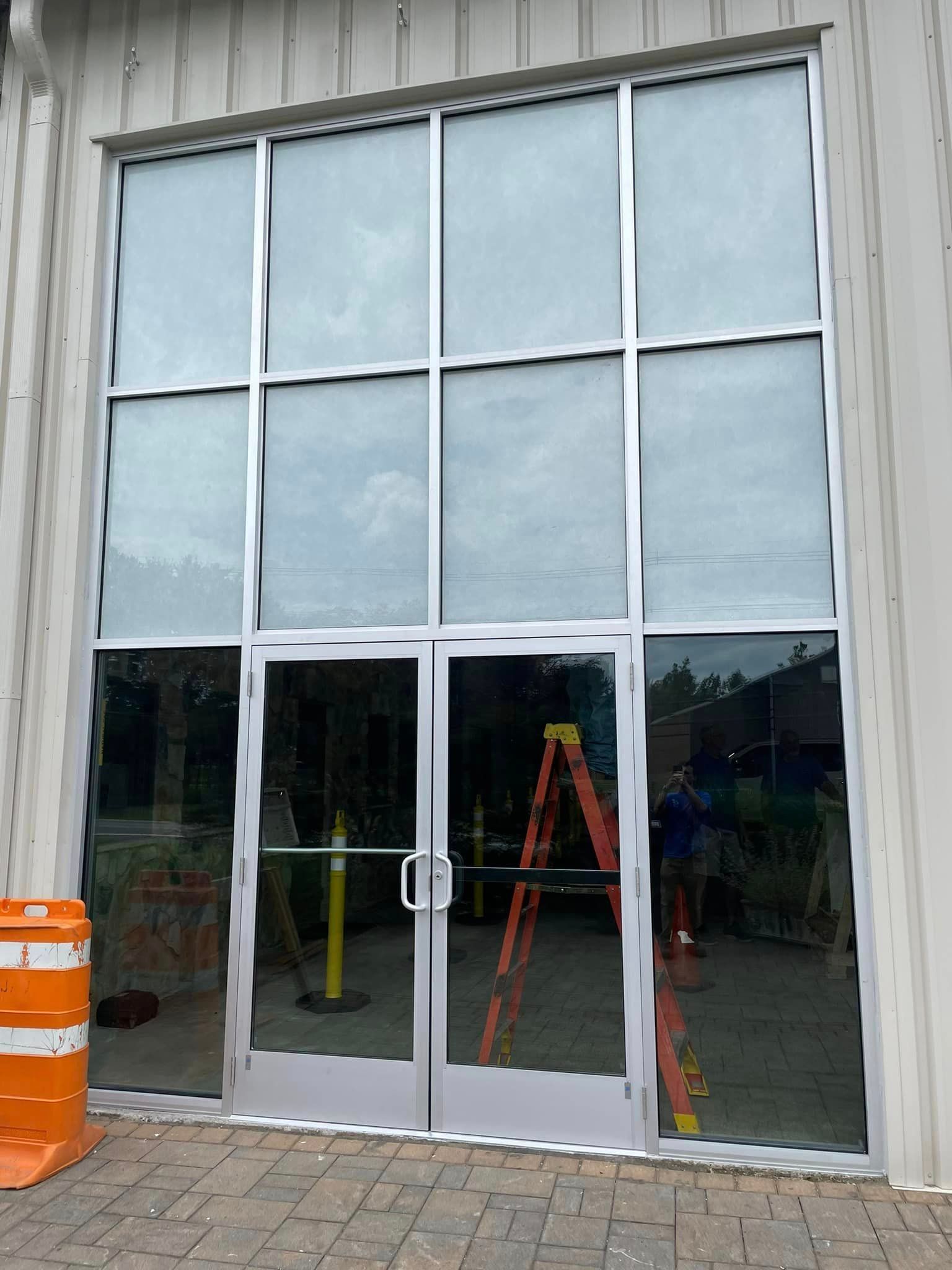 A large glass door with a ladder in front of it.