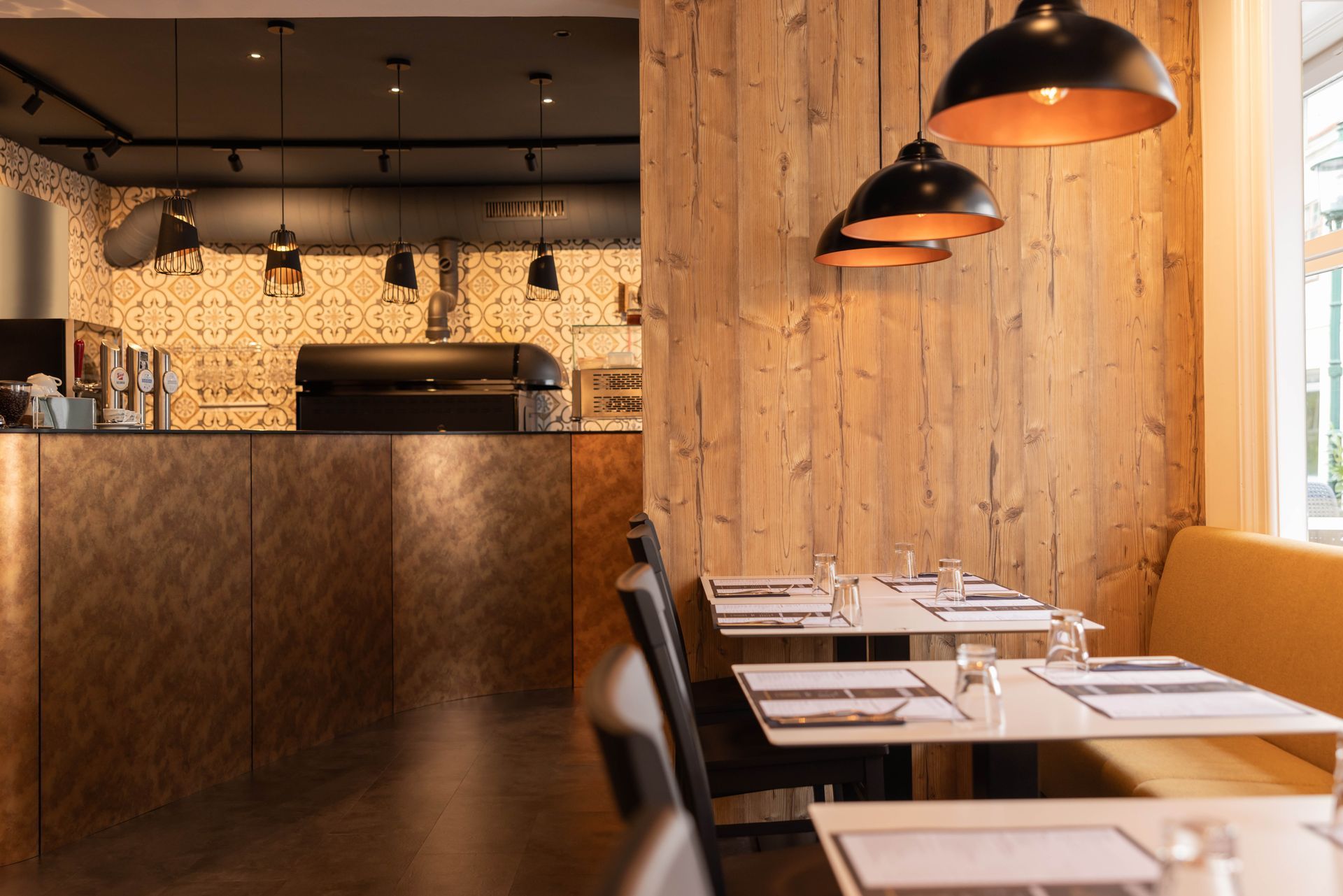 Ein Restaurant mit Tischen und Stühlen und einer Holzwand.