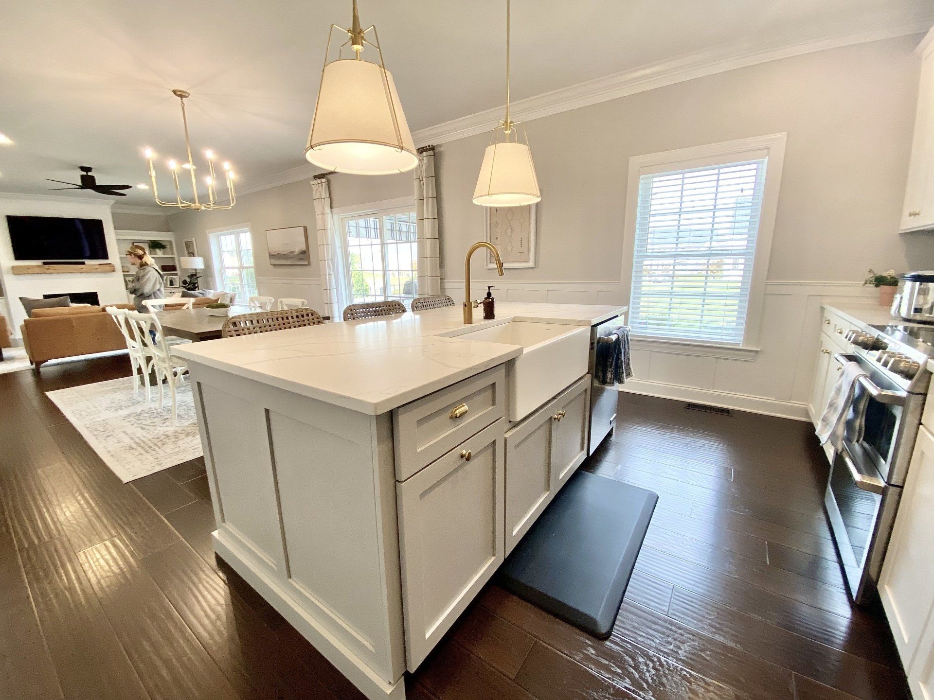 Bright white kitchen with large island, pendant lights, and stainless steel appliances