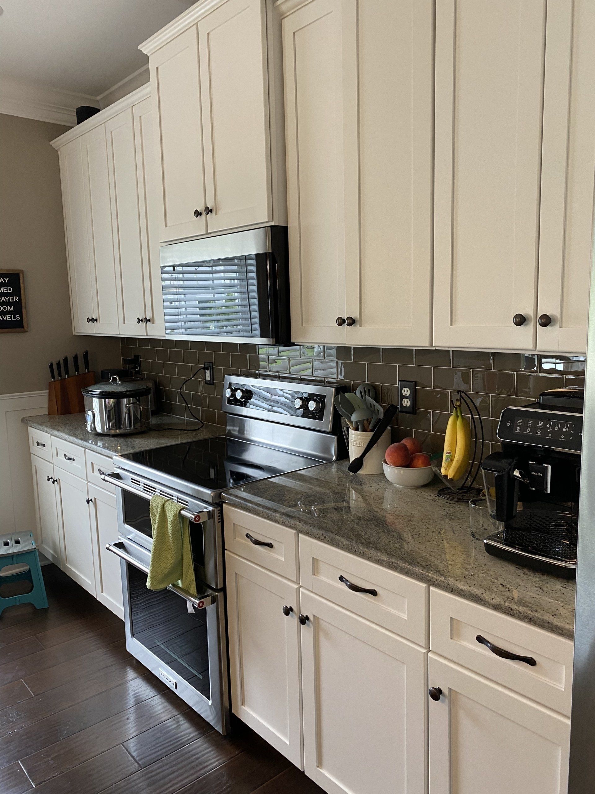 Kitchen with white cabinets, stainless steel stove, granite counters, and a few small appliances on the counter