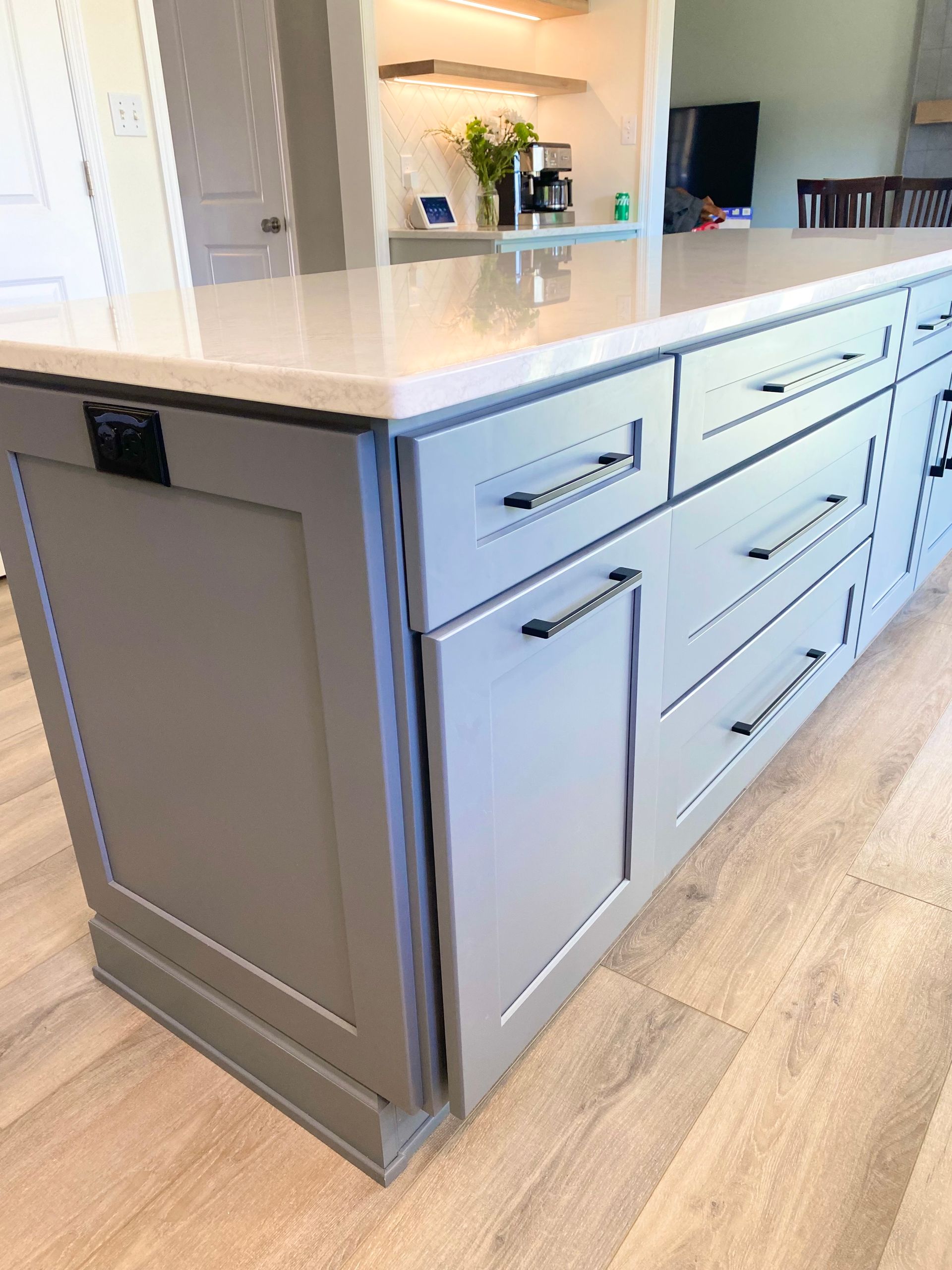 a kitchen with a large island and lots of cabinets and drawers .