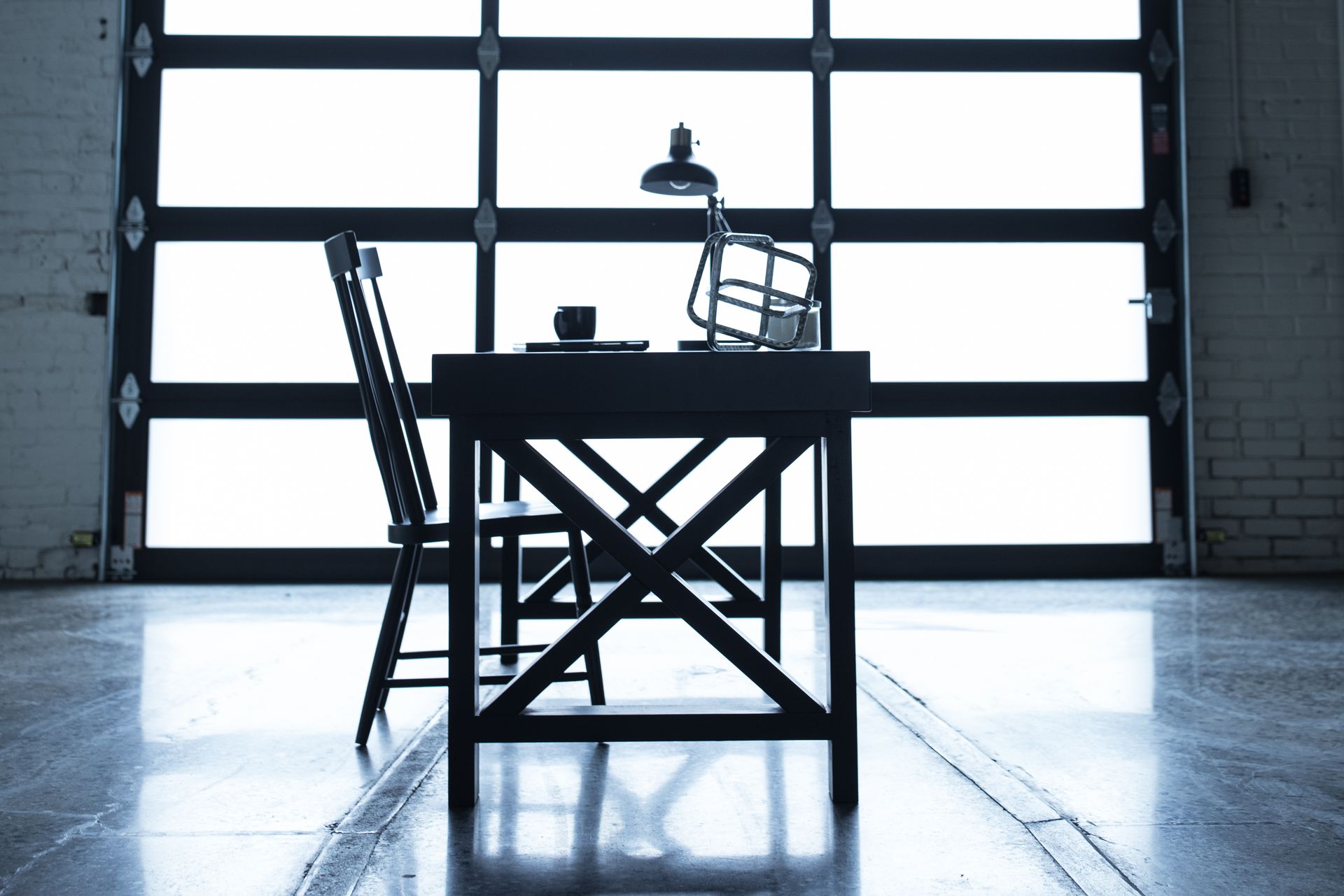Silhouetted director’s chair and table in a bright studio with a large garage door backdrop