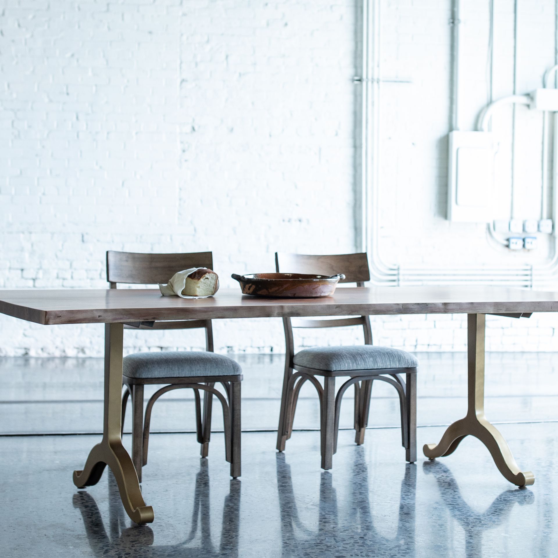 Minimal dining table with two chairs in a bright, white room