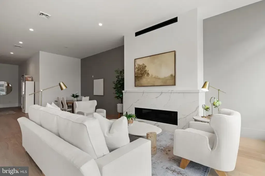 Bright modern living room with white sofa, fireplace, and wall art