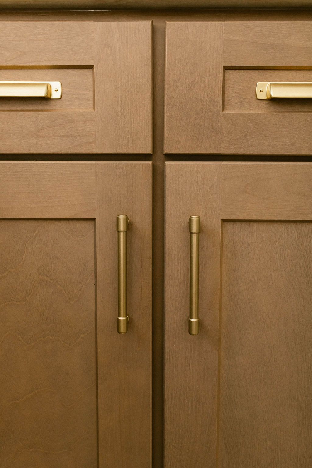 Brown kitchen cabinets with brass handles and drawers
