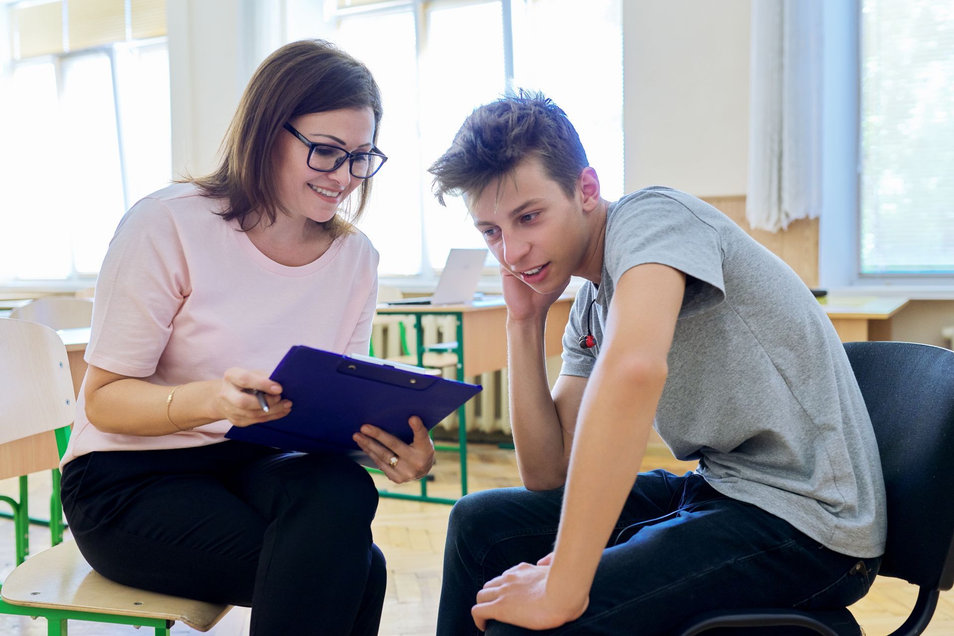 Young man listening to female behaviour support practitioner