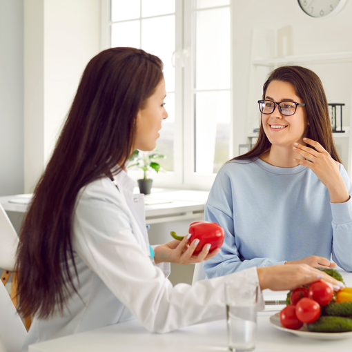 Two women discussing with assortment of fruits and vegetables in front of them