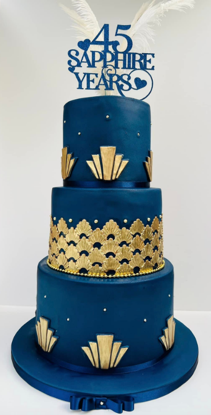 Blue and gold 45th anniversary tiered cake with “45 Sapphire Years” topper