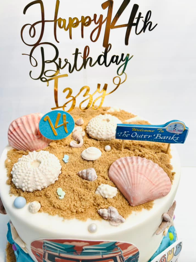 Happy 14th birthday cake with gold topper, seashell decorations, and blue plaque on a white base