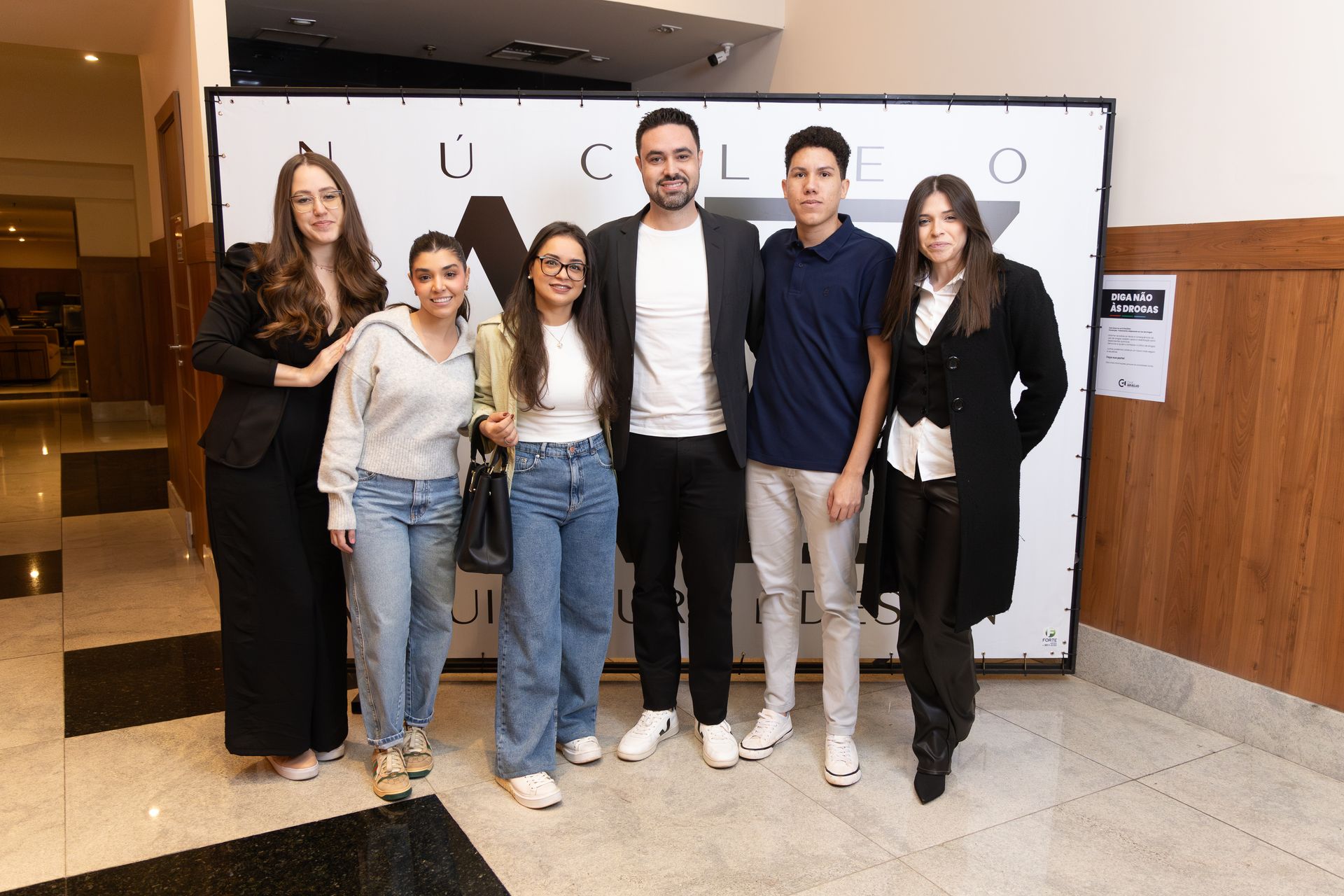 Um grupo de pessoas está posando para uma foto em um corredor.