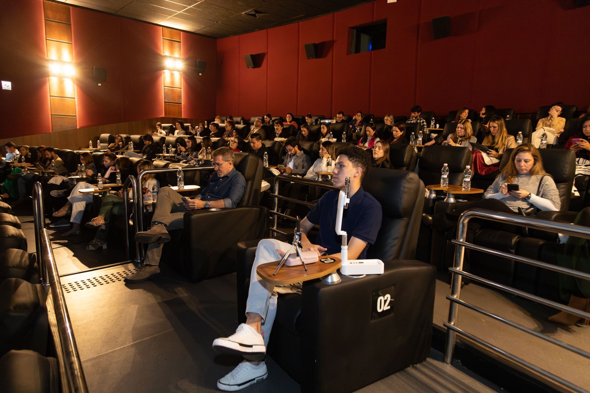 Um grupo de pessoas está sentado em um cinema assistindo a um filme.