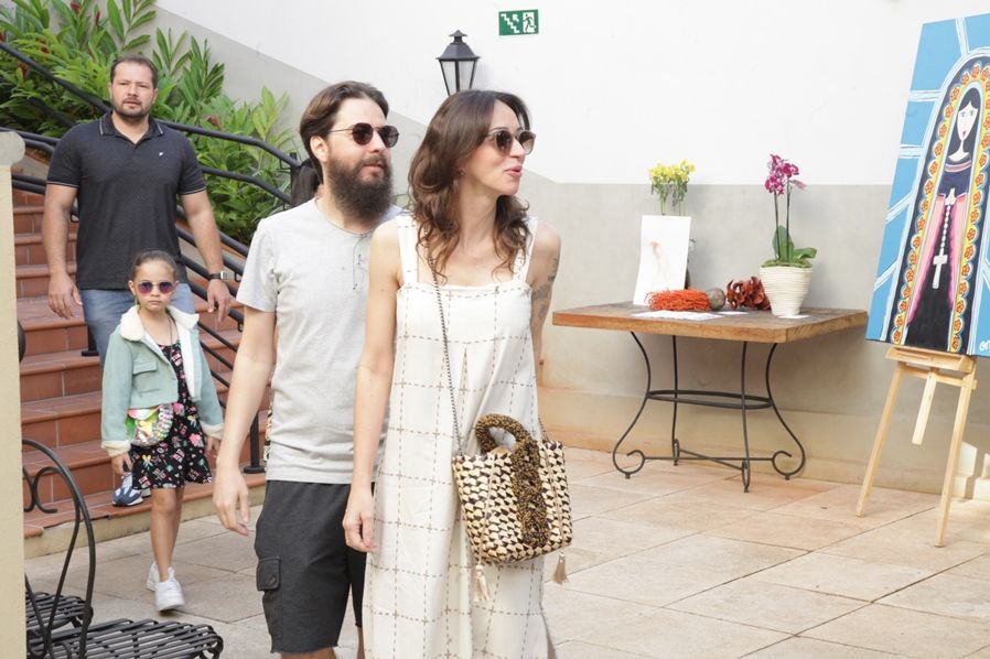 Um homem com barba está caminhando com uma mulher e uma menina.