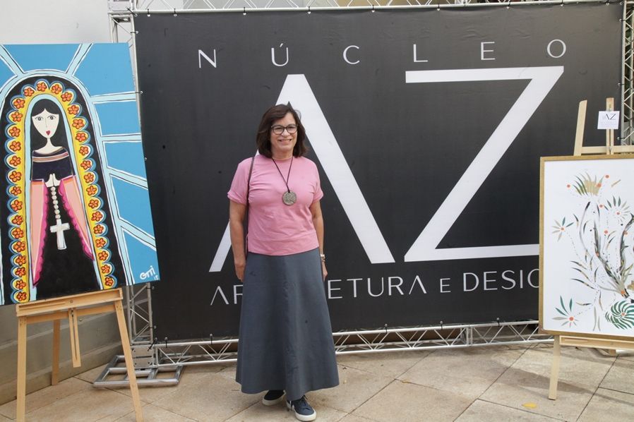 Uma mulher está parada em frente a uma placa que diz nucleo