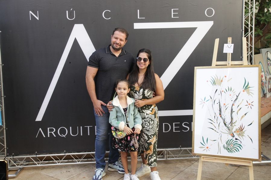 Uma família em pé em frente a uma placa que diz nucleo