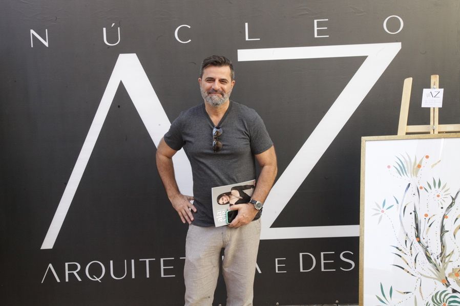 Um homem parado em frente a uma placa que diz nucleo